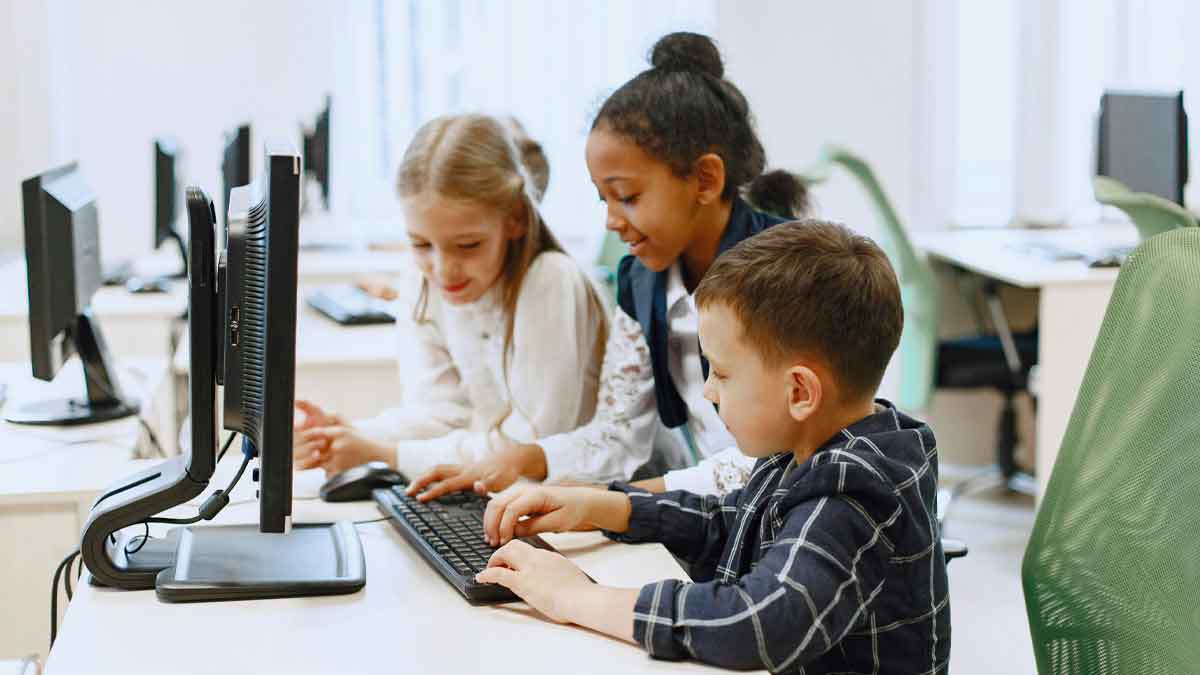 Niños y niñas usando ordenadores en el Campamento Digital: formación TIC gratuita con certificado oficial europeo