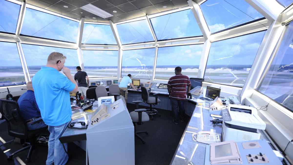 controladores aéreos en torre de control de aeropuerto español supervisan vuelos requisitos exámenes curso.