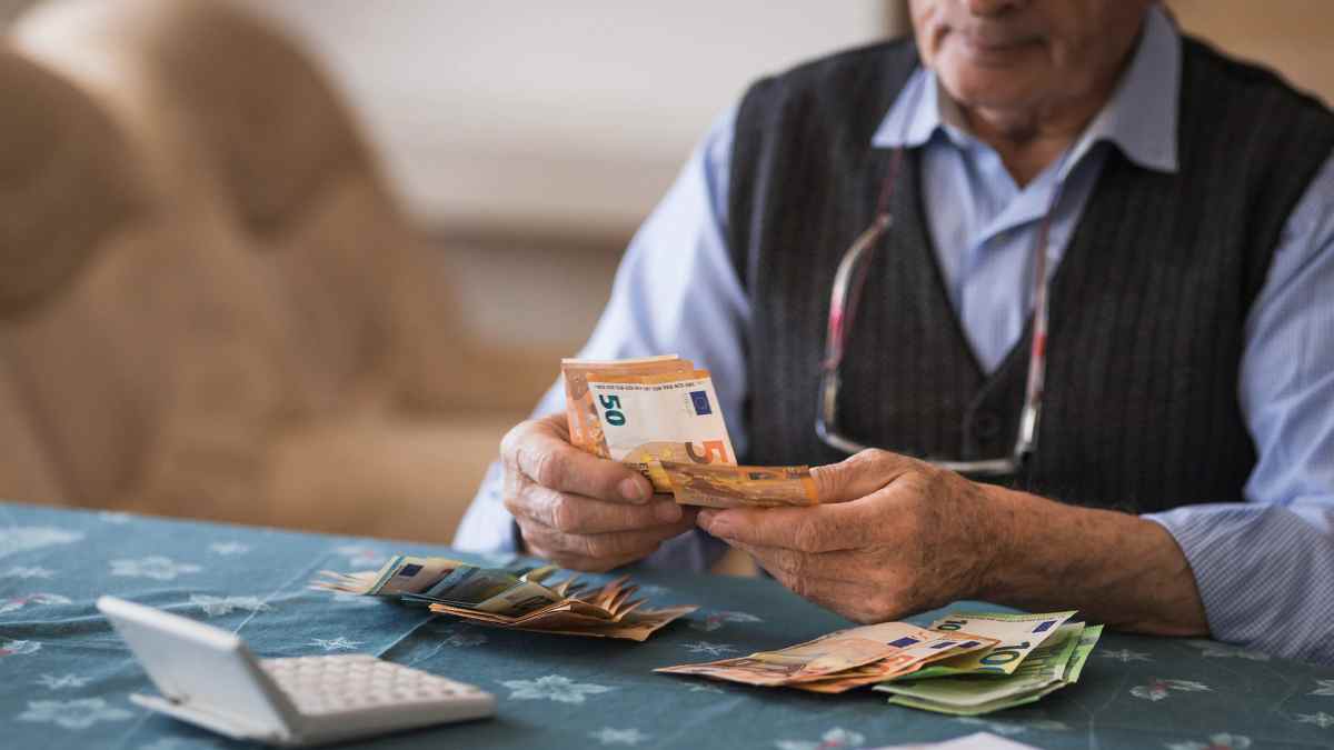 Jubilado contando billetes por devolución del IRPF a mutualistas.