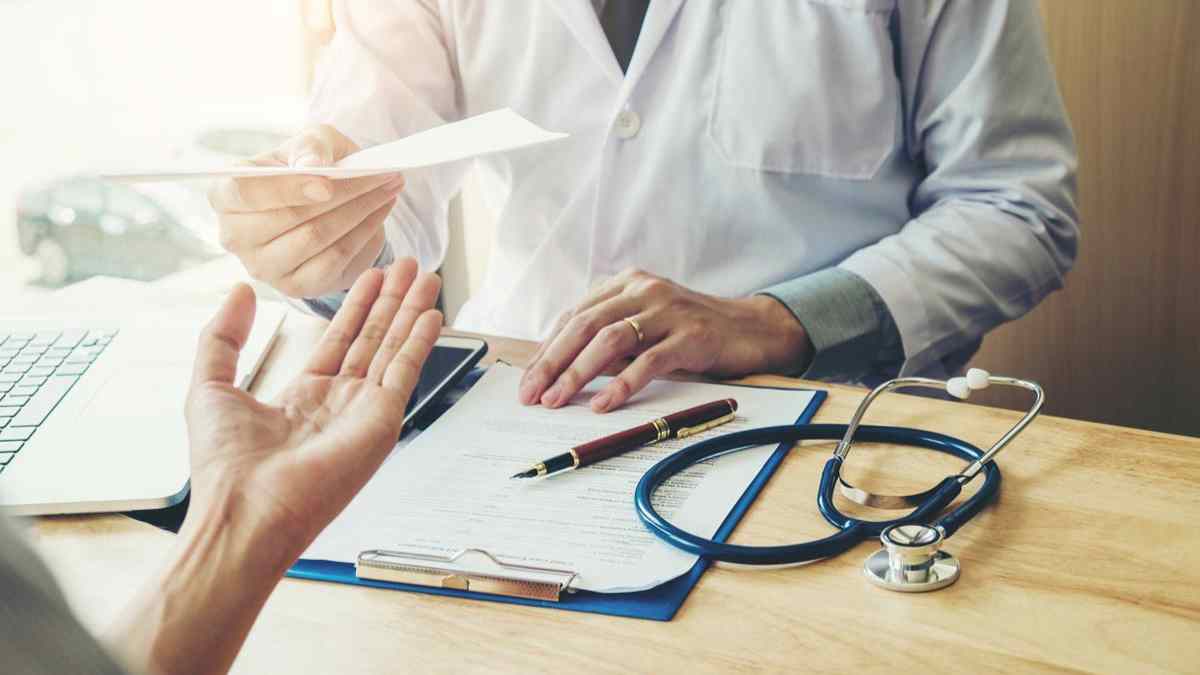 Trabajador en consulta médica durante baja laboral con informe.