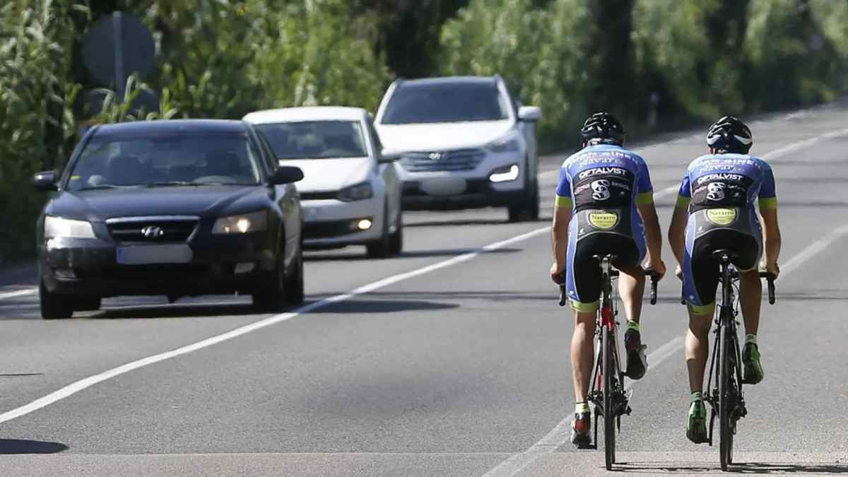 Ciclistas circulando por carretera junto a coches tras cambio de la DGT publicado en el BOE.