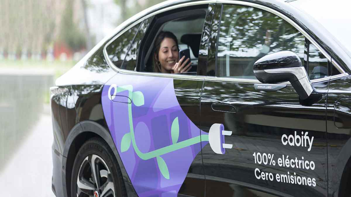 Vehículo eléctrico de Cabify con pasajera y rotulación 100% eléctrico cero emisiones.