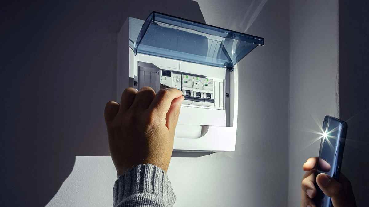 Persona revisando el cuadro eléctrico durante un corte de luz en Madrid.