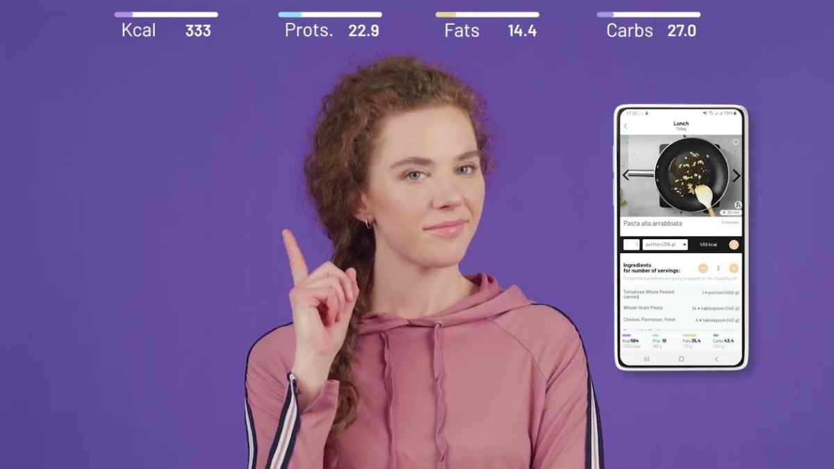 Mujer señalando la app Fitatu con inteligencia artificial que calcula calorías y macronutrientes a partir de una foto.