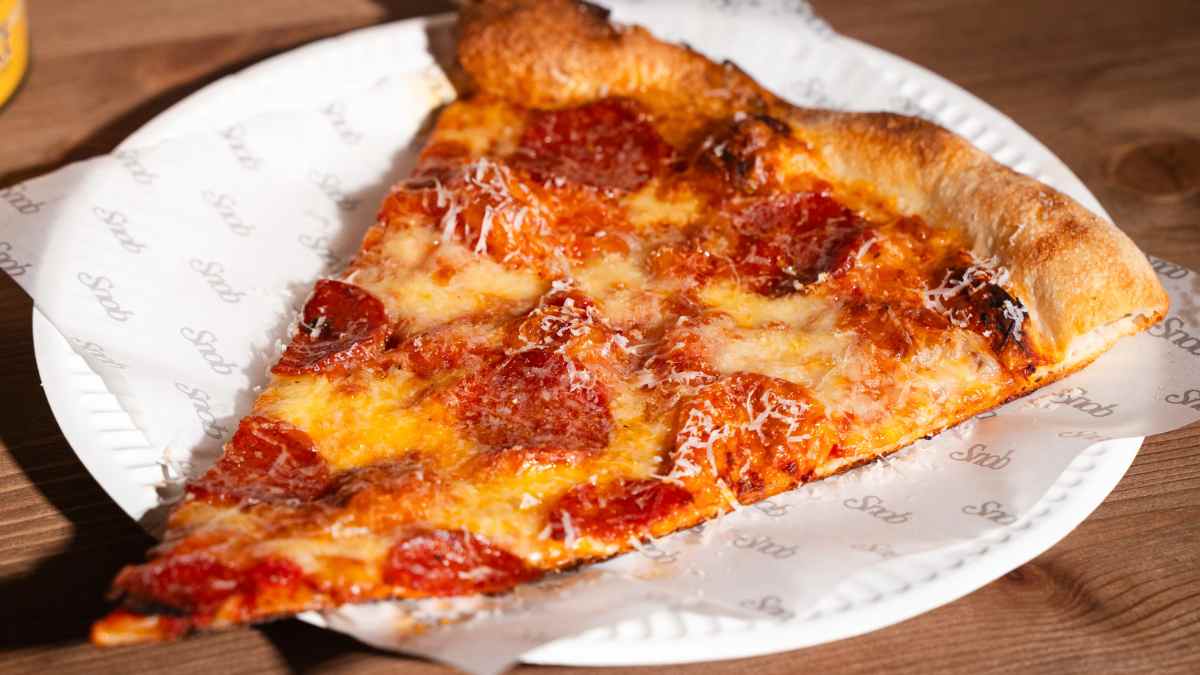 Porción de pizza neoyorquina con pepperoni en Snob, pizzería XXL de moda en Madrid.