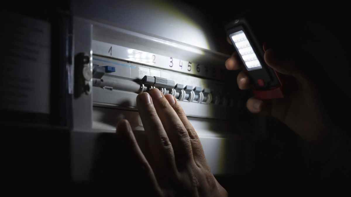 persona revisando el cuadro eléctrico durante un apagón programado en Madrid.