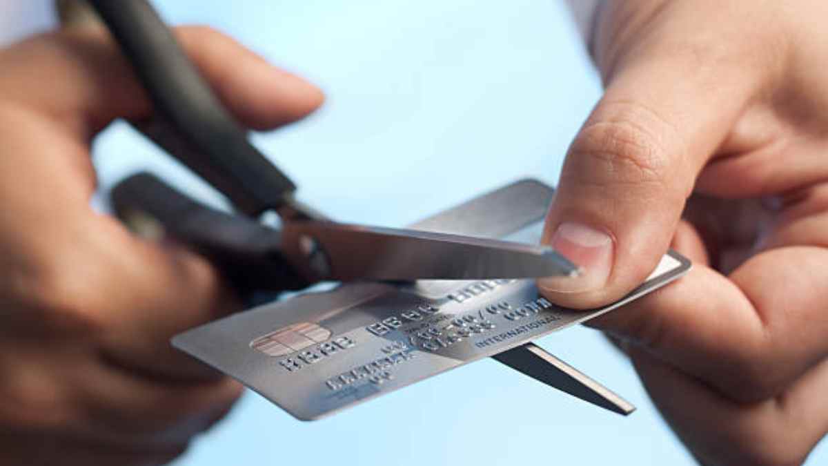 Persona cortando una tarjeta de crédito para simbolizar el fin de las tarjetas de crédito no solicitadas