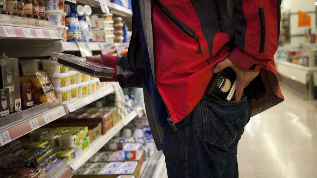 Trabajador ocultando productos en un supermercado durante su jornada laboral