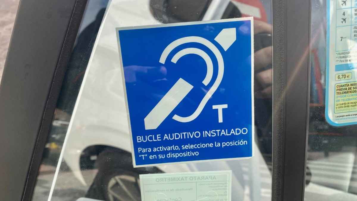 Pegatina azul de bucle auditivo instalada en la ventanilla de un taxi de Madrid
