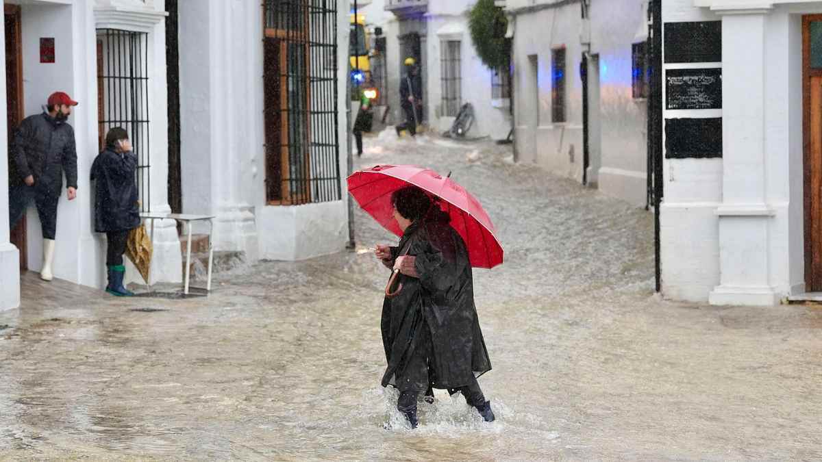 Mujer cruzando una calle inundada en España tras el temporal de la borrasca Oriana.