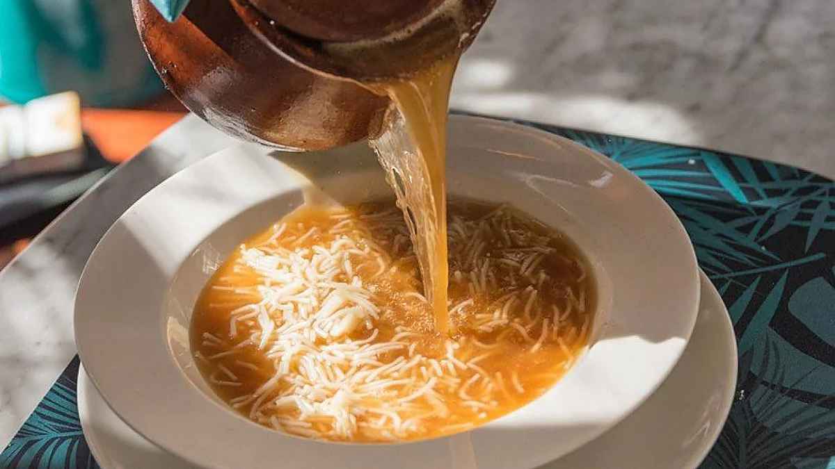 Caldo de cocido madrileño con fideos servido caliente en restaurante del centro de Madrid por el Día del Cocido