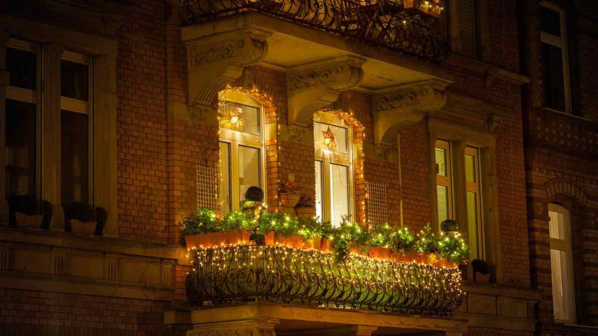 Balcón con luces decorativas instaladas en la fachada de un edificio en una comunidad de vecinos