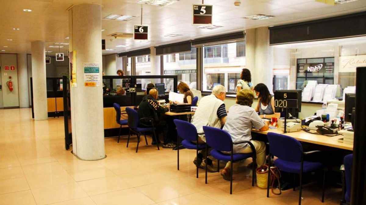 Oficina de la Seguridad Social con personas realizando trámites relacionados con pensiones e incapacidad permanente