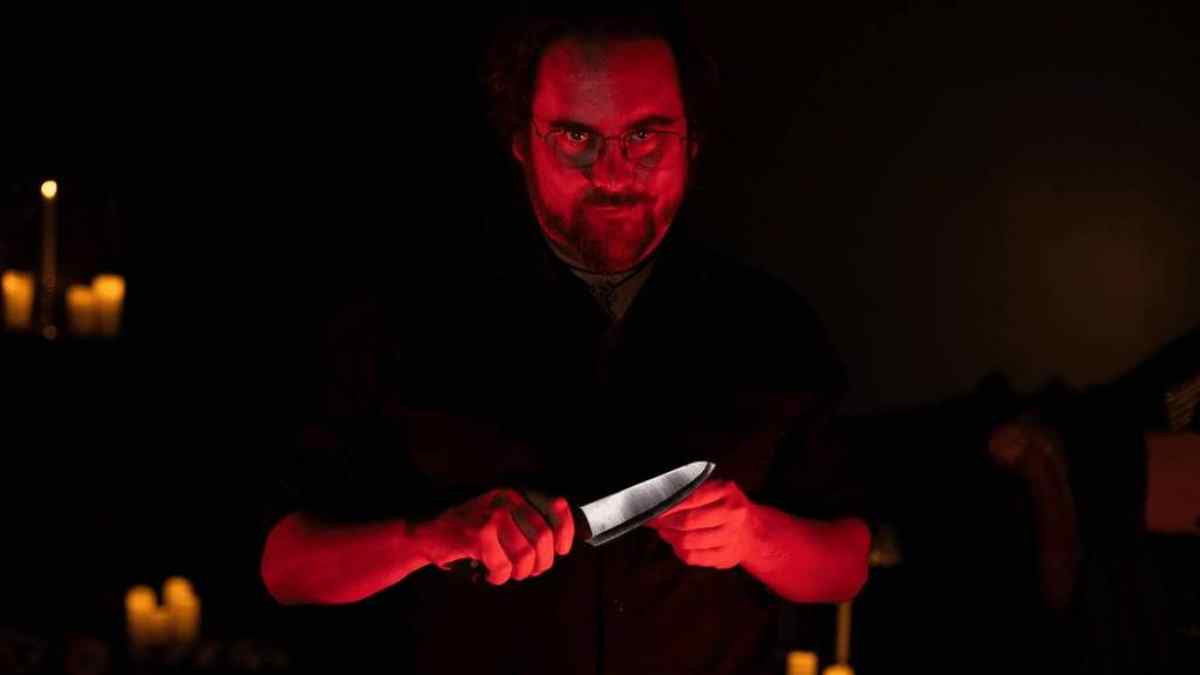 Hombre con cuchillo en ambiente oscuro durante la experiencia Serial Killer Speakeasy en Madrid