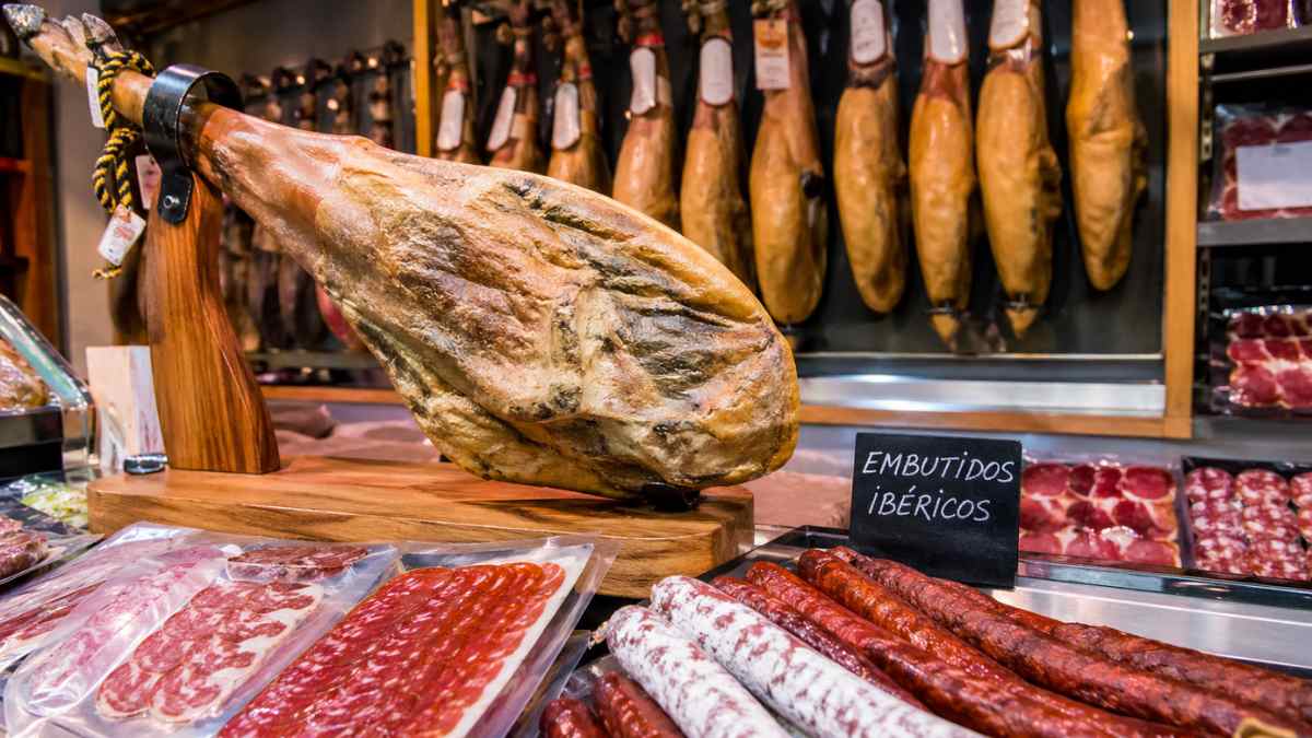 Jamón ibérico y embutidos en tienda con nueva normativa de calidad alimentaria en 2026