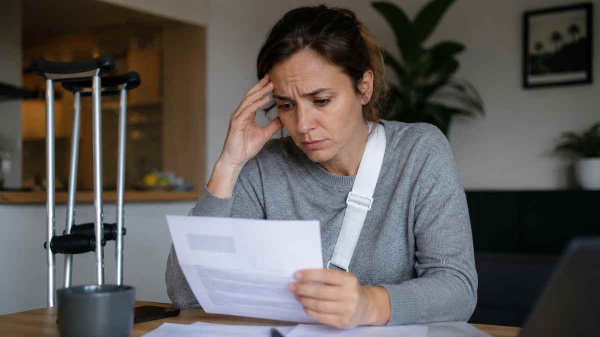 Trabajadora preocupada revisando una carta tras ser despedida durante una baja médica