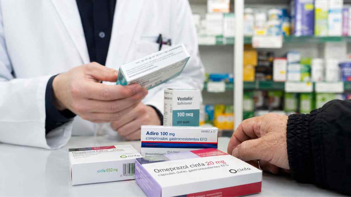 Farmacéutico entrega medicamentos a un pensionista tras los cambios del nuevo copago farmacéutico en España