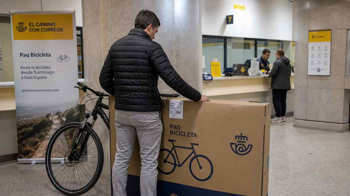 Hombre enviando bicicleta en oficina de Correos con el servicio Paq Bicicleta del Camino de Santiago