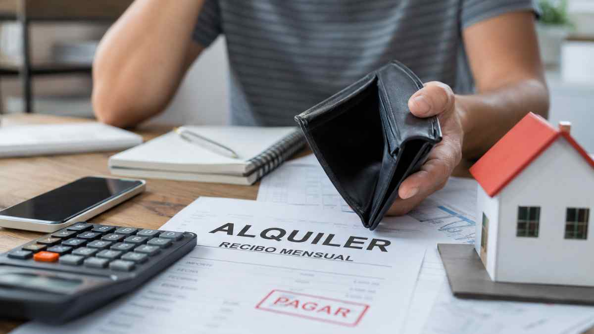 Inquilino preocupado mostrando una cartera vacía junto al recibo del alquiler mensual impagado