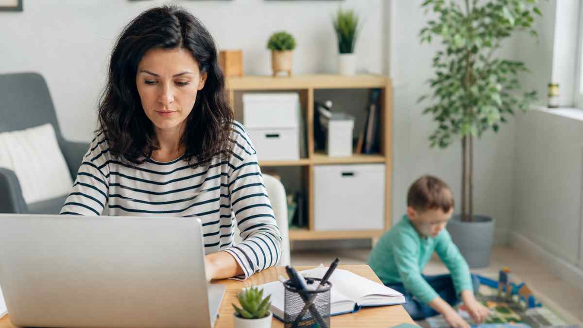 mujer trabajando desde casa con hijo pequeño conciliacion laboral reduccion jornada cuidado hijos