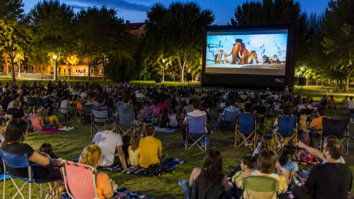 Público asistiendo al cine de verano gratis de Móstoles durante una proyección familiar al aire libre en Parque Coimbra.