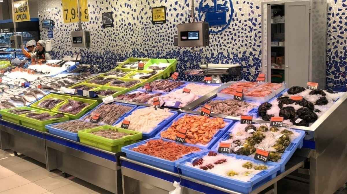 Pescadería de Mercadona con pescado y marisco expuestos en cajas azules y verdes