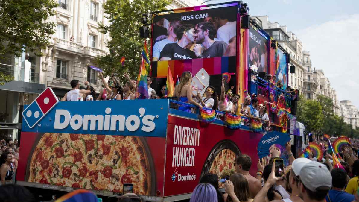 Carroza de Domino's durante el desfile del Orgullo de Madrid con asistentes y banderas arcoíris