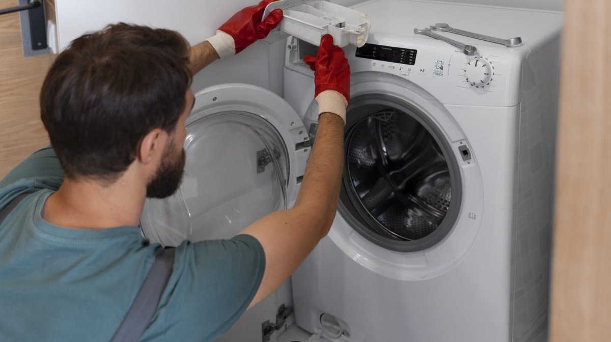 Técnico revisando una lavadora, uno de los electrodomésticos de alto consumo que debe conectarse directamente al enchufe de pared