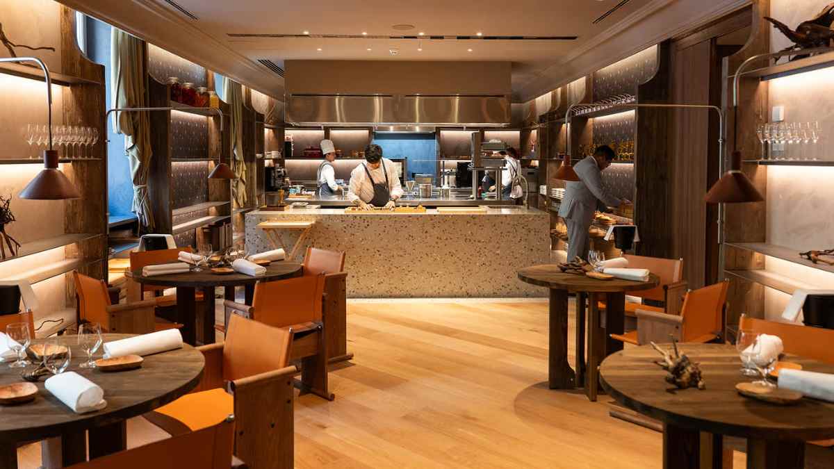Interior del restaurante La Sociedad Gastronomika de Eneko Atxa en Madrid con cocina vista y comedor principal