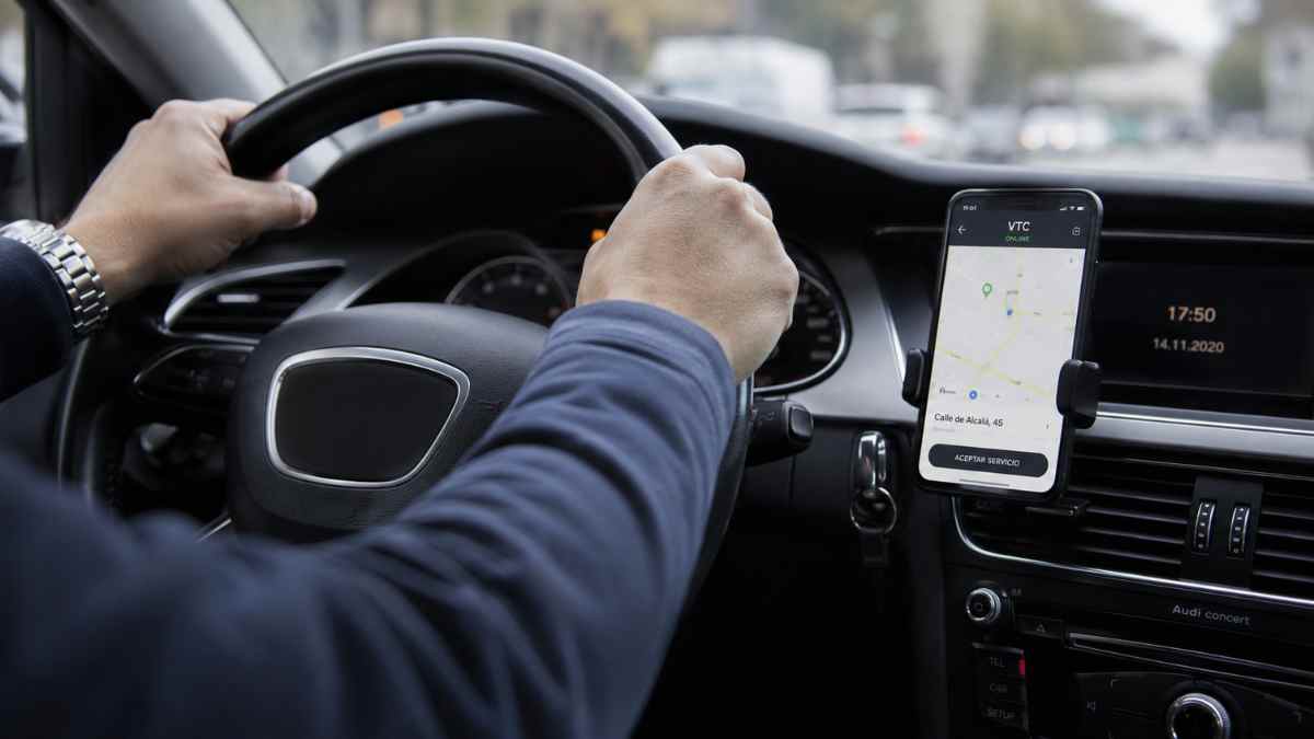 Conductor VTC al volante de un vehículo durante una jornada de trabajo en Madrid antes del examen obligatorio para obtener el permiso profesional
