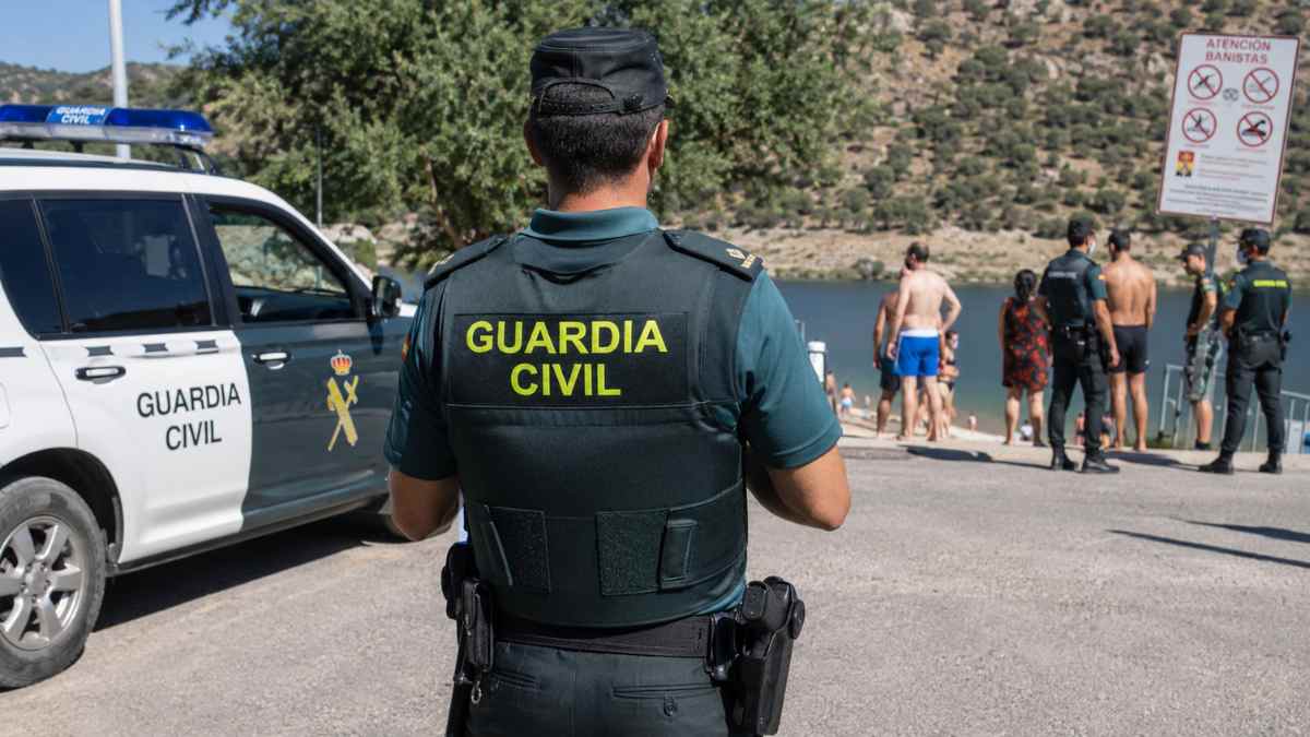 Agente de la Guardia Civil junto a un vehículo oficial vigilando una zona de baño durante la Operación Verano 2026 en Madrid