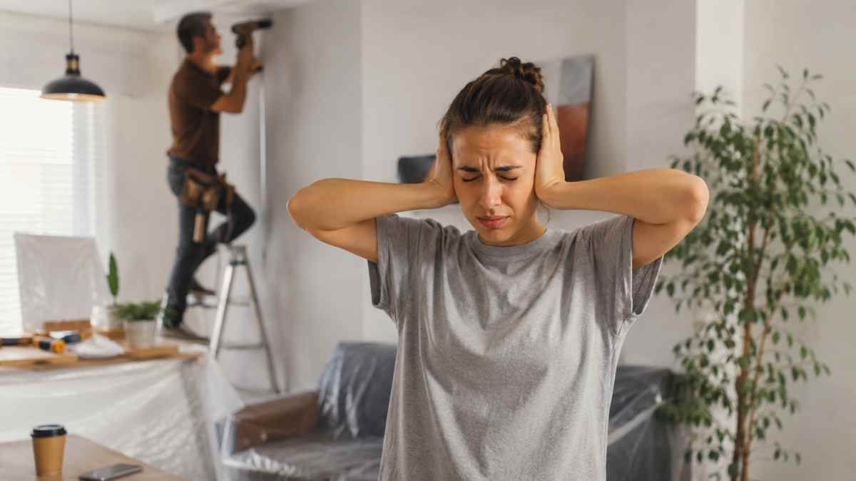 Mujer tapándose los oídos por el ruido de unas obras en una vivienda según la Ley de Propiedad Horizontal