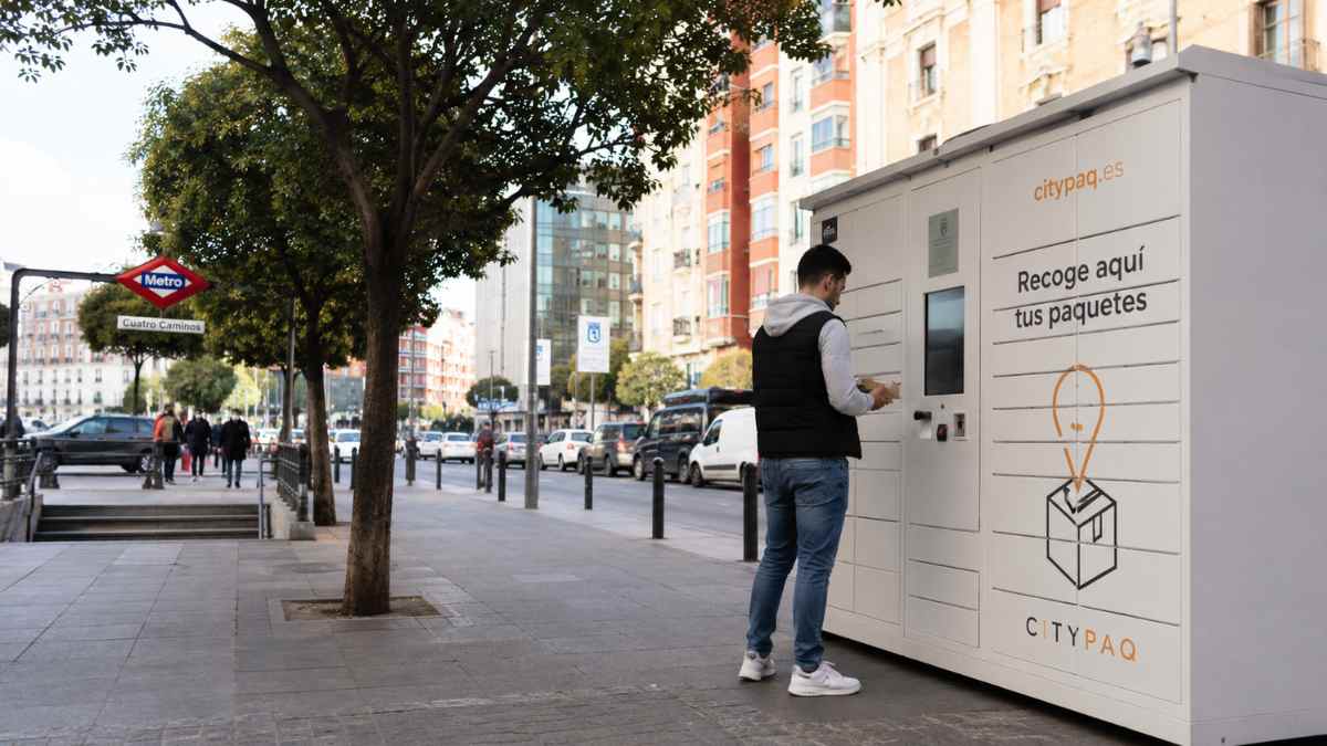 Usuario recogiendo un paquete en una taquilla inteligente instalada en una calle de Cuatro Caminos, Madrid.