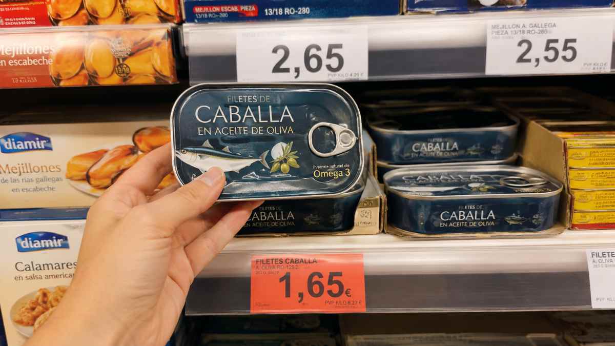 Consumidor sujetando una lata de caballa en un supermercado tras los cambios de etiquetado de conservas aprobados por el BOE