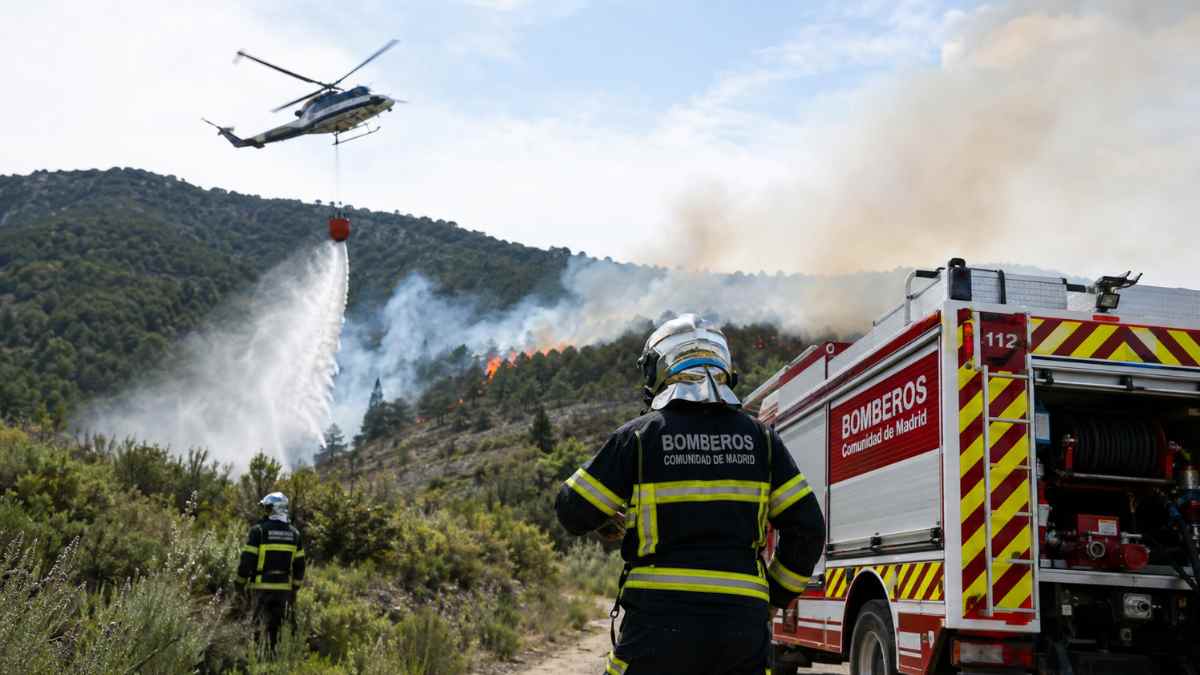Bomberos y helicóptero del Plan INFOMA 2026 trabajando en la extinción de un incendio forestal en la Comunidad de Madrid