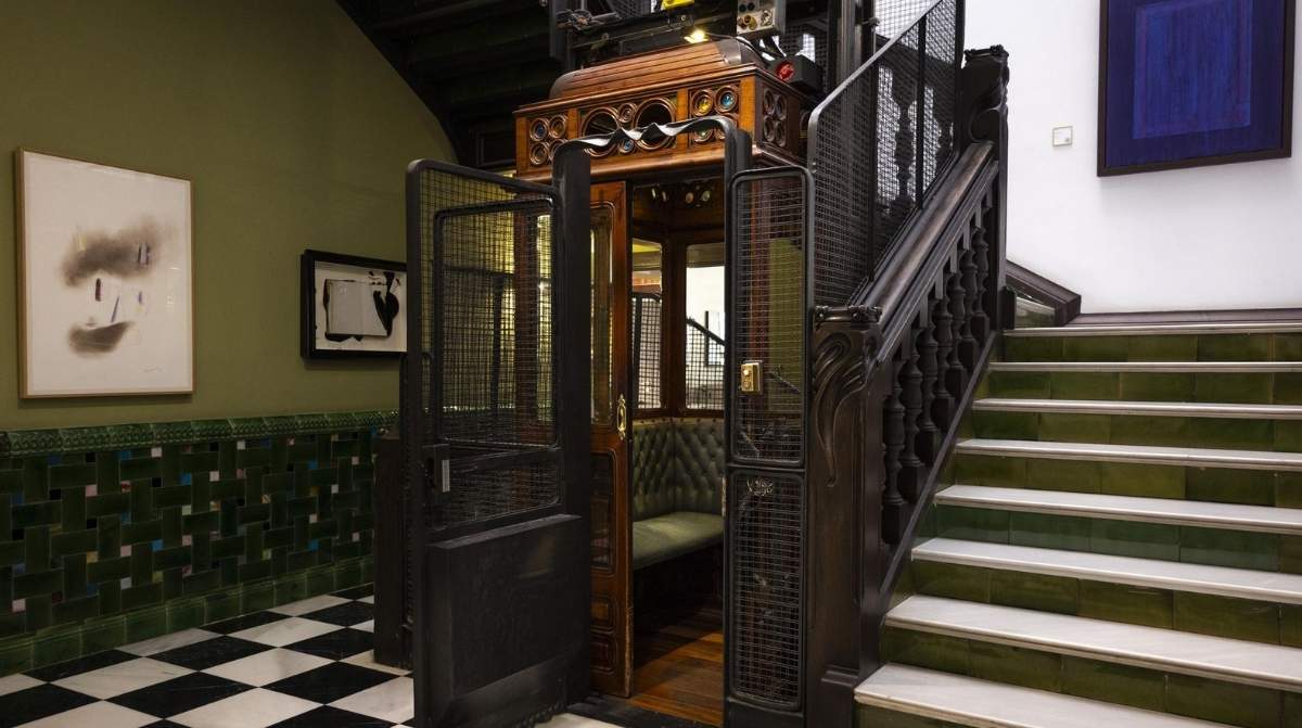 Ascensor antiguo de madera y hierro en un edificio histórico de Madrid