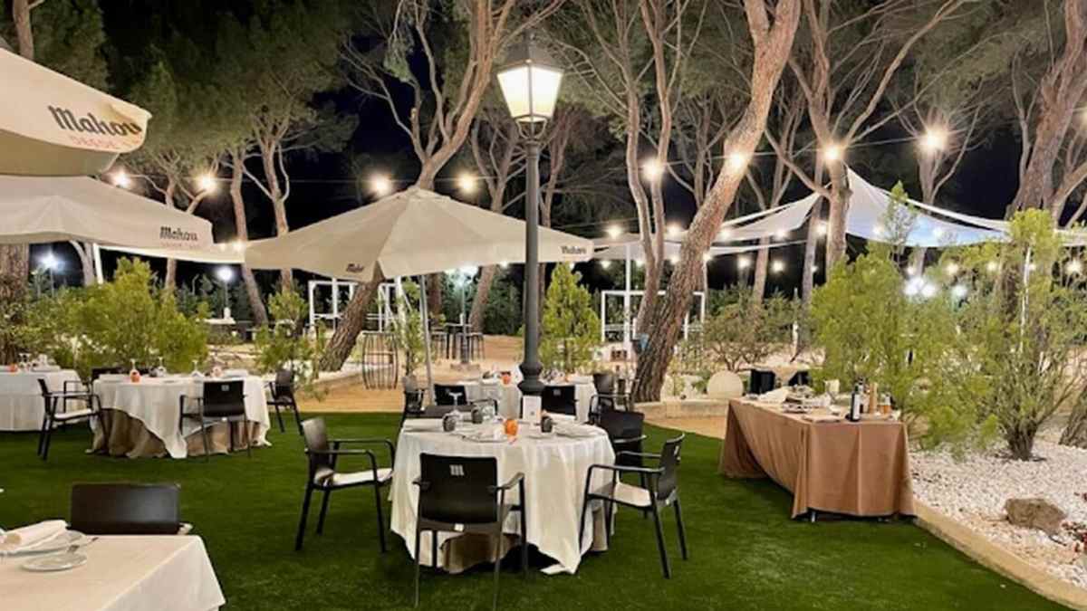 Terraza exterior del restaurante Lar de Domingo en El Pardo durante una noche de verano en Madrid