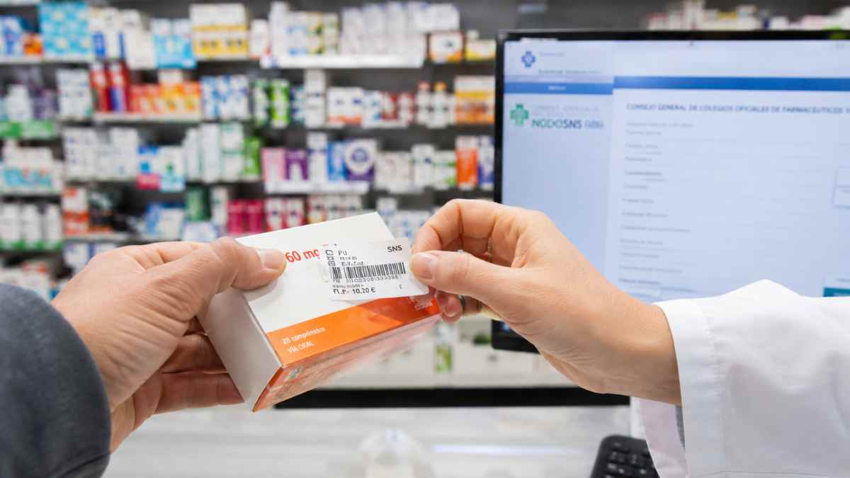 Farmacéutica retirando el cupón precinto de un medicamento financiado antes de su sustitución por el nuevo sistema digital de Sanidad