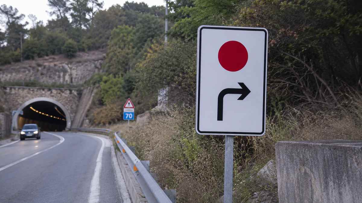 Señal de tráfico con flecha a la derecha y punto rojo que indica un desvío alternativo en carretera