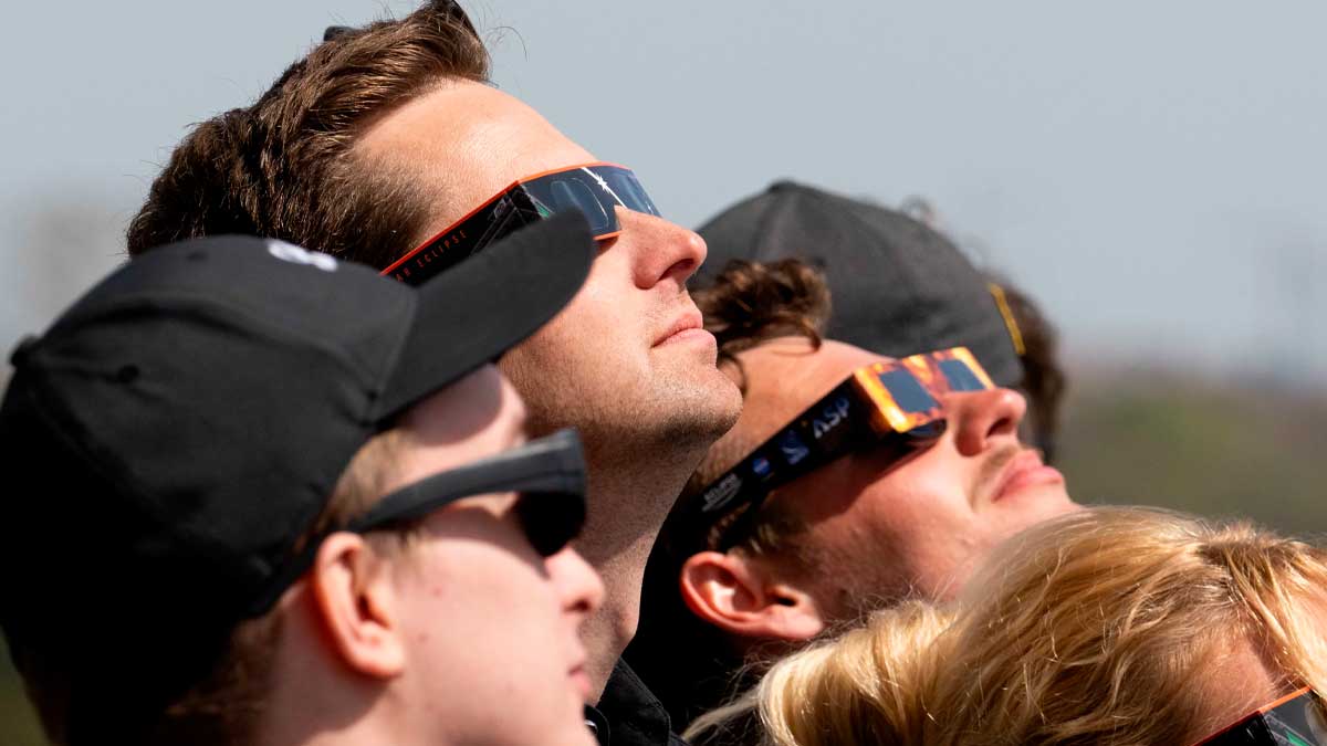 Personas con gafas para eclipse observando el cielo en Madrid durante el eclipse solar 2026