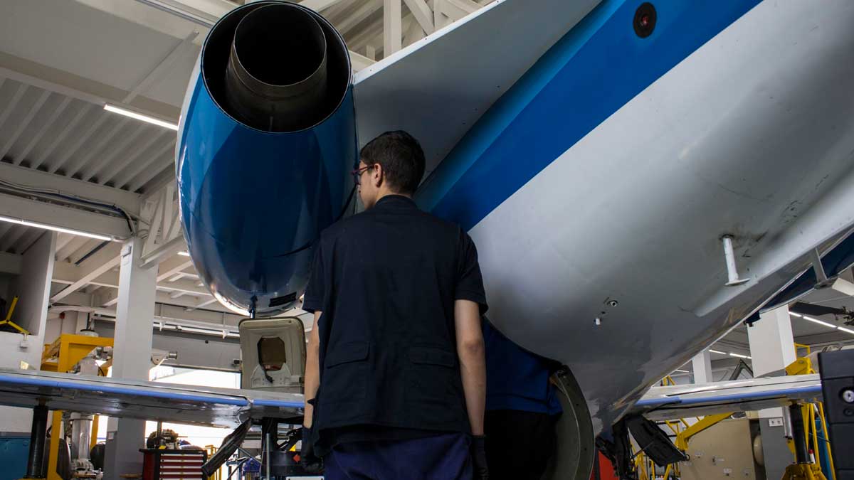 Técnico revisando motor de avión en hangar, industria de defensa Madrid