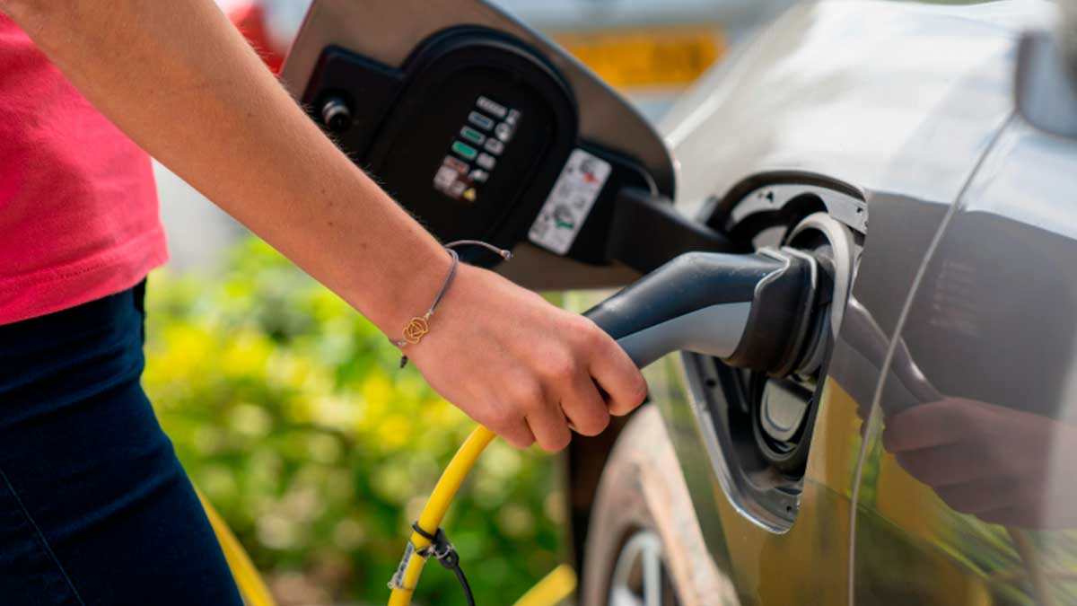 Persona cargando un vehículo eléctrico en un punto de recarga tras la nueva dotación de ayudas del programa MOVES III en Madrid.