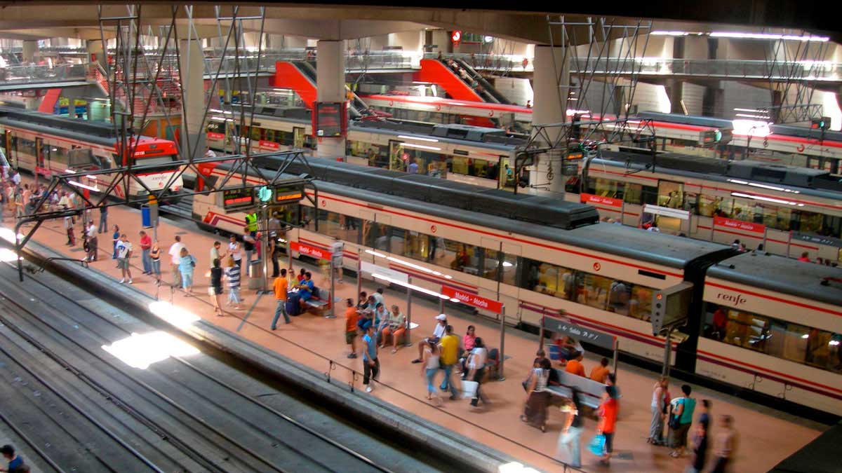 Andén de la estación de Atocha con pasajeros y trenes de Cercanías afectados por retrasos