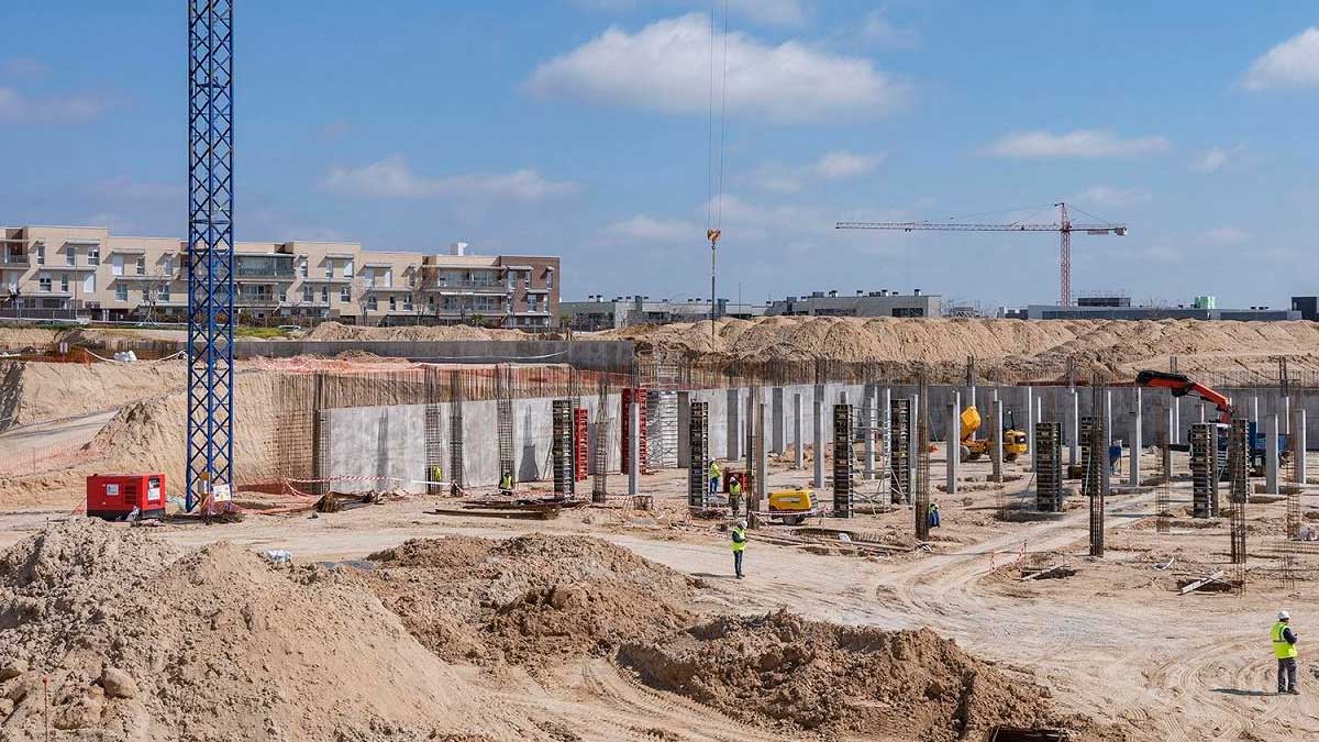 Construcción de viviendas protegidas en Madrid con grúas y operarios en obra