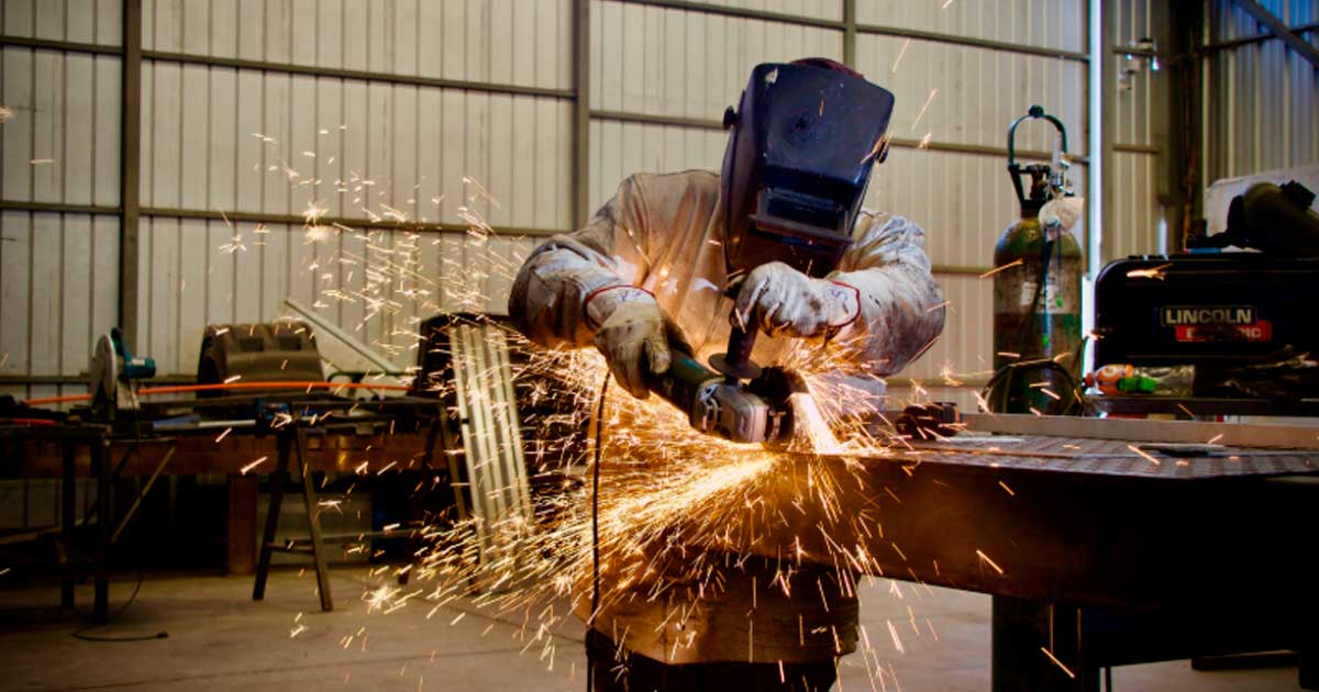 Trabajador del sector industrial realizando tareas con una radial