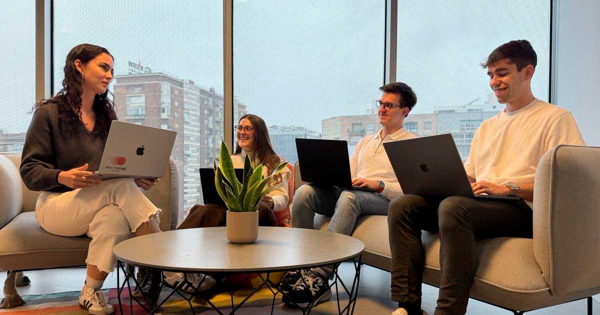Jóvenes trabajando con ordenadores portátiles en una oficina de Madrid