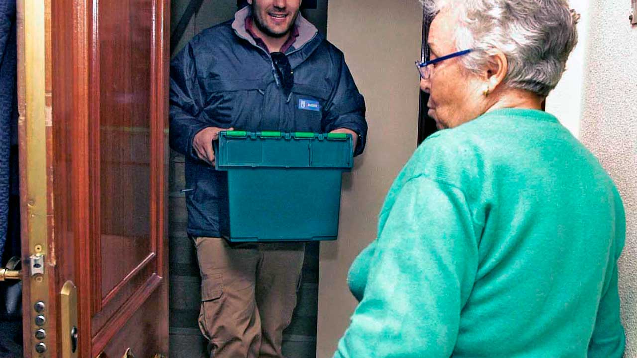 Mujer recibe comida del comedor social a domicilio en Madrid