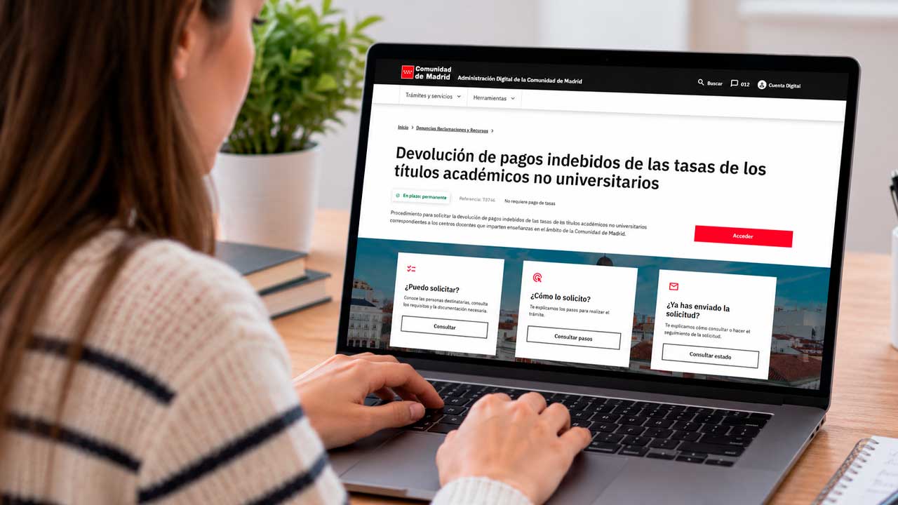 Joven consulta en un portátil la devolución de tasas de títulos académicos en Madrid