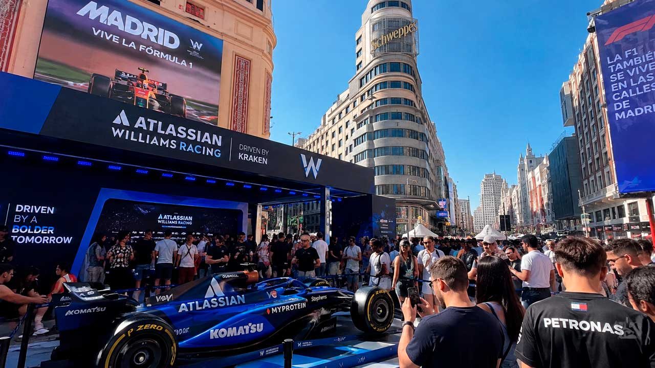 Aficionados junto a un monoplaza de Fórmula 1 en una Fan Zone en el centro de Madrid