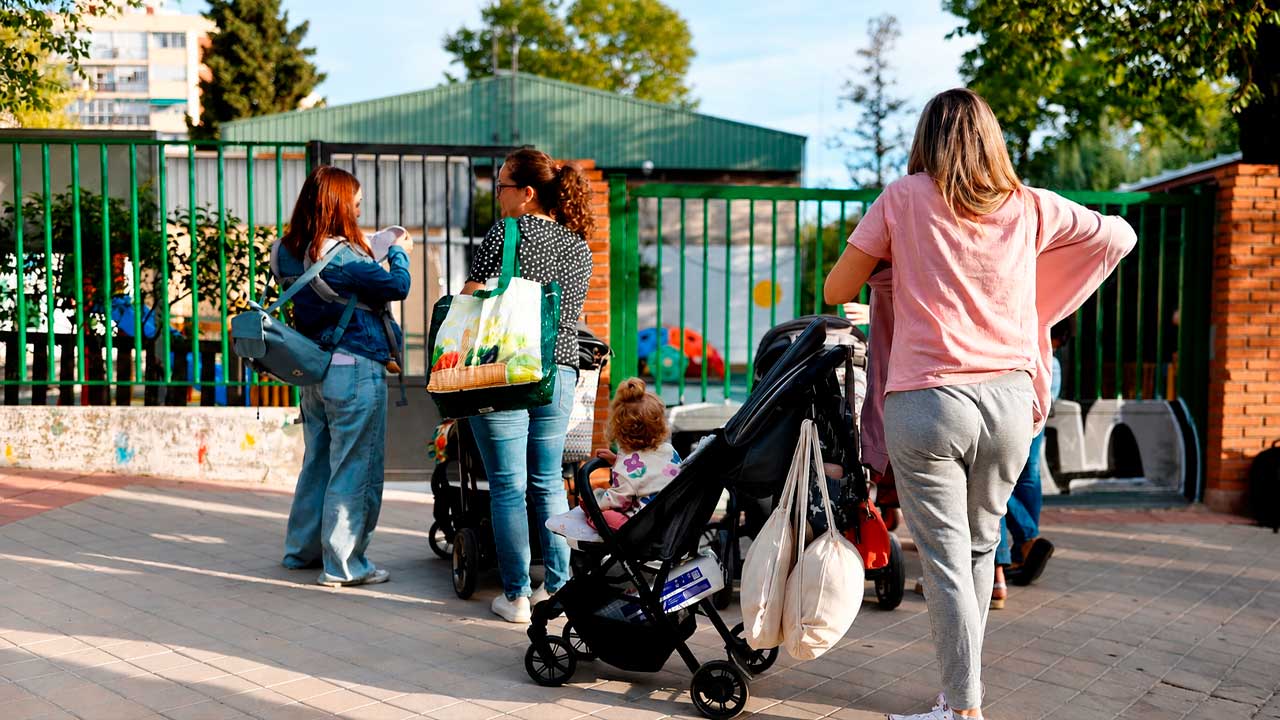 Familias con niños pequeños a la entrada de una escuela infantil en Madrid